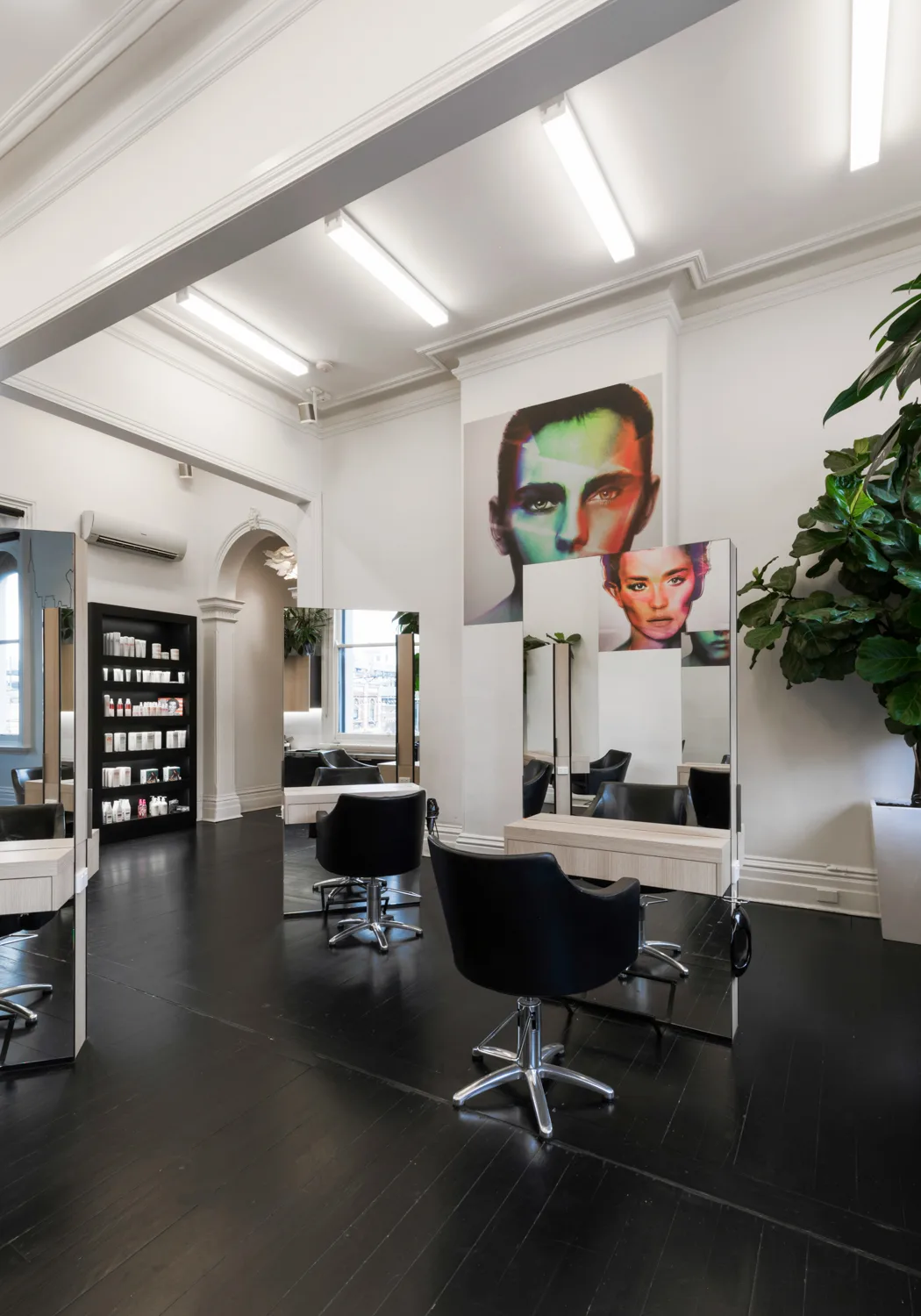 Cream Melbourne styling floor — green and pink pop-art portraits, fiddle-leaf fig, mirror stations