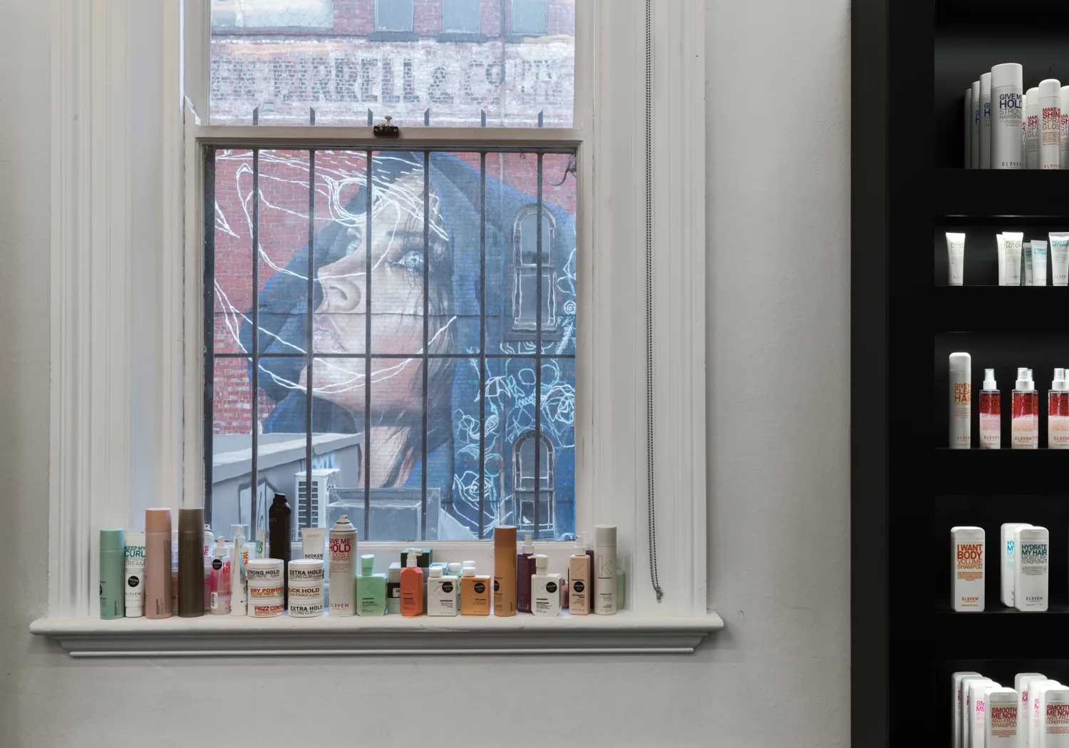 ELEVEN and Redken products on the windowsill at Cream Melbourne, framing the Fitzroy street-art mural outside