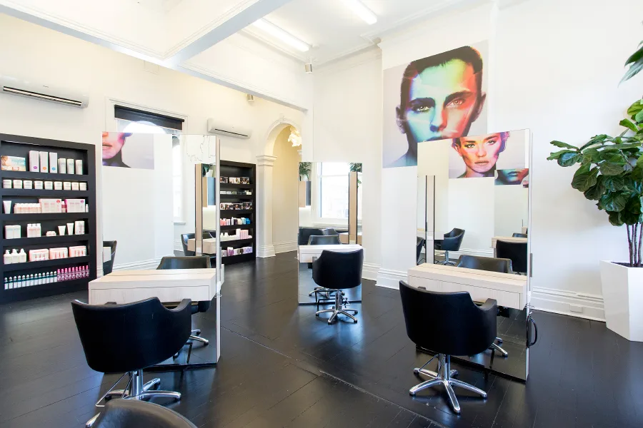 Cream Melbourne styling area — mirror stations, product shelf, arched doorway