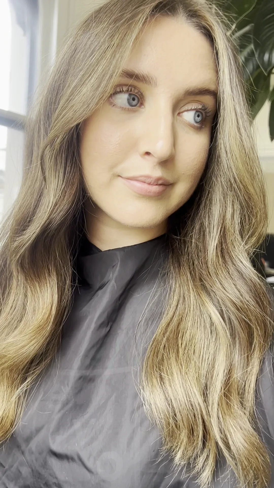 A client with long balayage waves in a black salon gown at Cream Melbourne